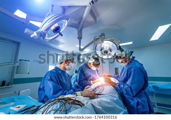 Neurourgeons are operating with medical\
robotic surgery machine. Modern automated medical device. Surgical\
room in hospital with robotic technology equipment, machine arm\
neurosurgeon.