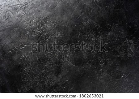 Neutral black stylish photographic background imitating the texture of a table made of natural stone.