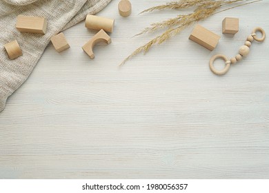 Neutral nursery, baby background, flat lay composition with natural wood building blocks, toys, blanket, dried plants on washed wood table, copy space. - Powered by Shutterstock