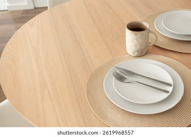 Neutral table setting with coffee mug on wooden table in dinning room, close-up