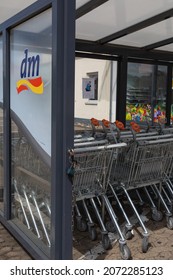 Neuwied, Germany - June 20, 2021: Logo Of The German Retail Drugstore Chain Dm On A Vitreous Divider Wall With Shopping Carts In A Row. 