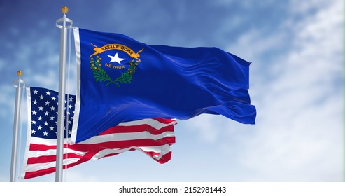 The Nevada state flag waving along with the national flag of the United States of America. In the background there is a clear sky. Nevada is a state in the Western region of the United States - Shutterstock ID 2152981443