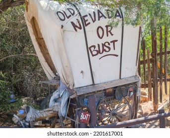 Nevada USA - August 15 2008; Small Covered Wagon Stationary Under Tree With Sign Old Nevada Or Bust Painted On White Cover