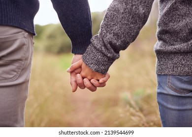 Never Far Apart. Cropped Shot Of A Couple Holding Hands While Outside.