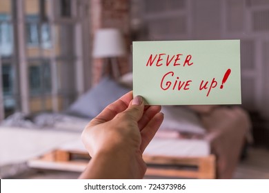 Never give up Motivation Poster Concept in female hand loft apartment  background  Inspirational   conceptual image for hope  winning  never give up  struggle  persistence  motivation
