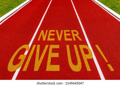 Never Give Up Written On Stadium Running Track.