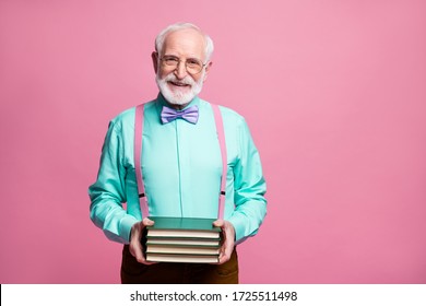 Never late study concept. Photo of amazing aged hipster grandpa hold many books hands elderly student wear specs mint shirt suspenders bow tie pants isolated pastel pink color background