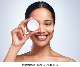 Never Looking Outside To Be Saved. Portrait Of An Attractive Young Woman Applying Moisturiser Against A Grey Background.