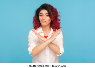 Never, No Compromise! Portrait Of Dissatisfied Hipster Woman With Fancy Red Hair Crossing Hands, Showing X Sign, Ban Or Prohibition Gesture, Rejecting Offer. Studio Shot Isolated On Blue Background