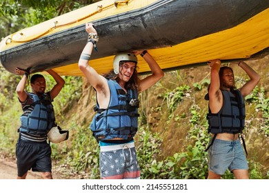 Never stop exploring. Shot of a group of friends on their way to the river with a raft.