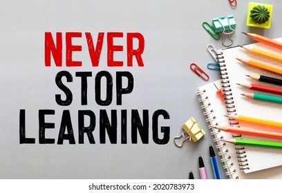 Never stop learning memo written on a notebook with pen. - Shutterstock ID 2020783973