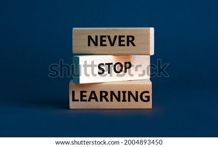 Never stop learning symbol. Wooden blocks with concept words Never stop learning. Beautiful grey background, copy space. Business, educational and never stop learning concept.