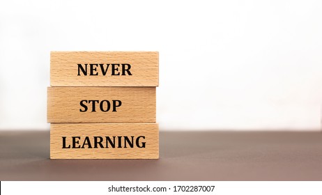 Never stop learning word written on wood block on white background. Time to say text on wooden table for your desing, concept.