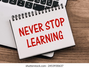 Never stop learning written on a memo stick. Lifelong learning concept.