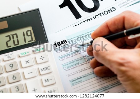 New 2019 IRS 1040 tax form, instructions, pen and calculator