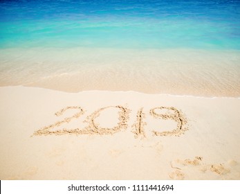 New 2019 year in the South, the sea. Sea surf. Blue wave is coming ashore. Inscription on sand, celebrate new year in the tropics. New year holidays