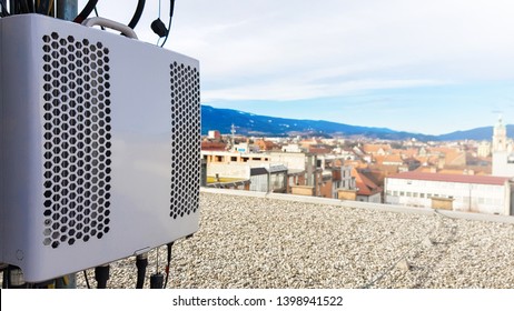 New 5G Radio Network Telecommunication Equipment Smart Radio Modules Mounted On A Metal Tower Providing Power For Radio Antennas To Radiate Strong Signal Waves Over The Dense Urban City 