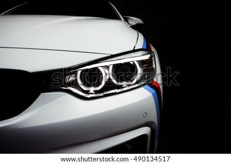 New aggressive headlight by night. Car details. The front lights of the sports car. Car's light. Insurance concept
