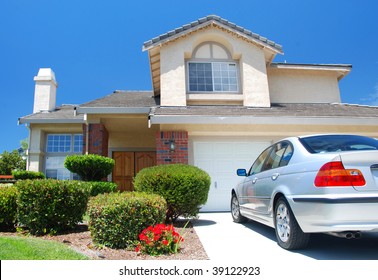 New American dream home with a beautiful blue sky in background and brand new car parked outside