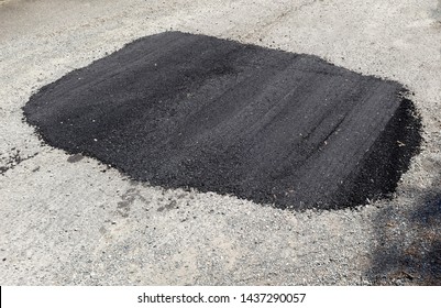 New Asphalt Repair Patch Of Pothole On City Street.