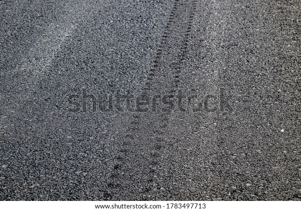 New asphalt surface with\
tire tracks