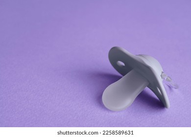 New baby pacifier on purple background, closeup. Space for text - Shutterstock ID 2258589631