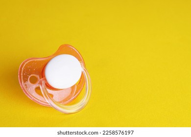 New baby pacifier on yellow background. Space for text - Shutterstock ID 2258576197