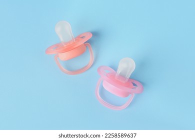 New baby pacifiers on light blue background, flat lay - Shutterstock ID 2258589637