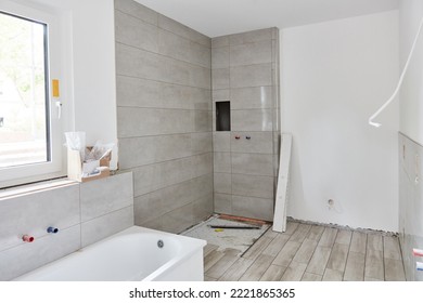 New bathroom with shower and bath with new tiles after repainting at home construction - Shutterstock ID 2221865365