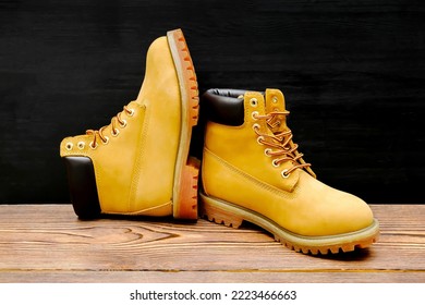 New beautiful brown yellow warm mountain women's winter Timberland tracking shoes, boots, sneakers, trainers logo on wooden background.Sport casual footwear concept - Shutterstock ID 2223466663