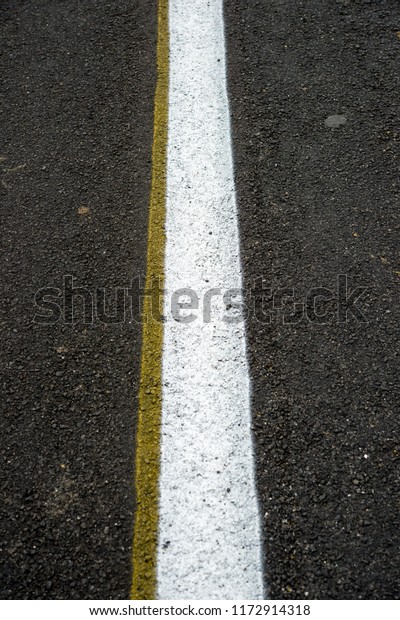 New black\
asphalt road with white dividing\
strip