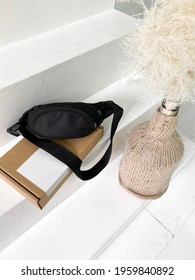 New Black Sling Or Hip Bag On The Blank Cardboard Box