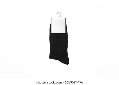 New Black Socks On A White Background. Black Socks Mock-up With A Blank Label. High Resolution Photo.