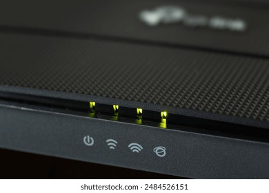 new black wifi router with green light on in office.