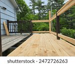 New boards and railings being installed on a small deck after the old deck had begun to rot.