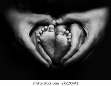 New born baby's feet on parents hand - Black and White image - Powered by Shutterstock