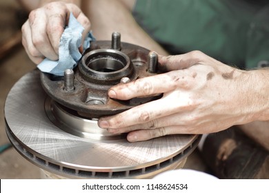 New Brake Rotor And Brake Pads Being Installed On A 2001pickup Truck. Neutral Color Scheme. Important For Safe Travels. Do It Yourself Brake Repair. Cleaning The Rotor Assembly