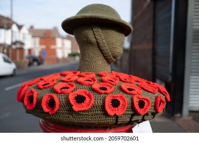 New Brighton UK October 2021 Red Poppy Fund Raiser Royal British Legion Appeal On Top Of Red Postal Boxes With Knitted Tommy And Helmet Armistice Day 