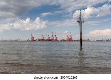 New Brighton, Wirral, UK - August 4 2021: Lateral Mark Post Indicating River Channel Edge On The Mersey Estuary. Cranes Of Seaforth Docks In The Distance.