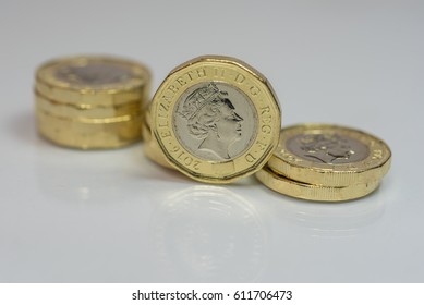 New British one pound coins up close macro studio shot against a shiny reflective White background