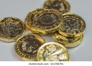 New British one pound coins up close macro studio shot against a shiny reflective White background