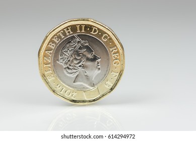 New British one pound sterling coin up close macro studio shot against a shiny reflective White background