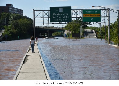 New Brunswick, NJ USA - September 2, 2021: Woman Walks On Highway Median After Ida Floods Town. 