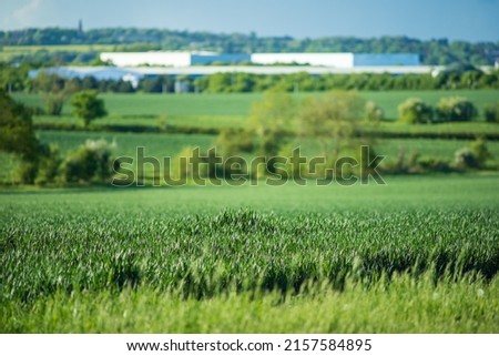 new built distribution warehouse building with farm fields in foreground in england uk