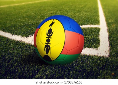 New Caledonia flag on ball at corner kick position, soccer field background. National football theme on green grass. - Powered by Shutterstock