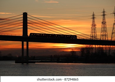 The new Canada Line, a rapid transit commuter train, crosses the Fraser River from Richmond and the airport into Vancouver at dawn. - Powered by Shutterstock