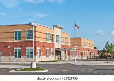 A new Canadian elementary school building with flagpole and parking lot.