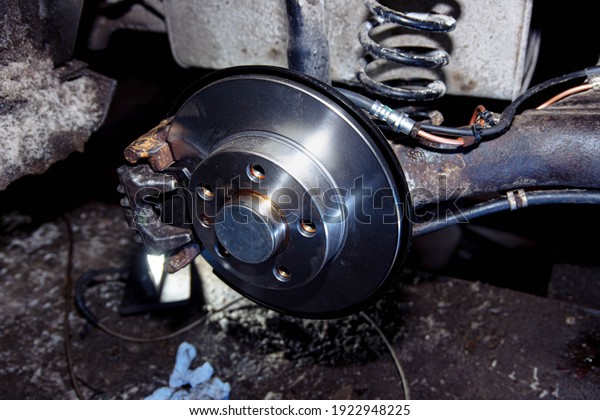 New\
car brake disc, brake system repair concept in\
garage