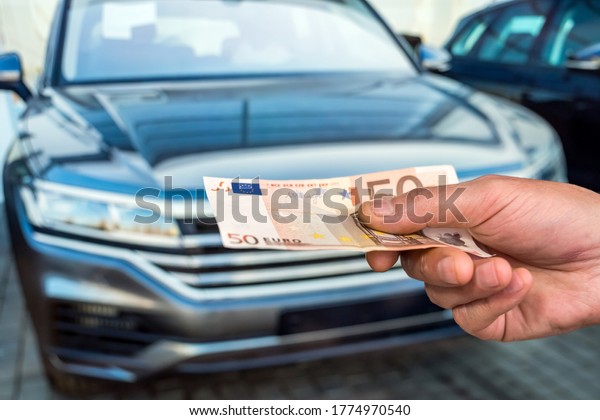 new car. buy or rent. hand holding euro\
banknotes. finance