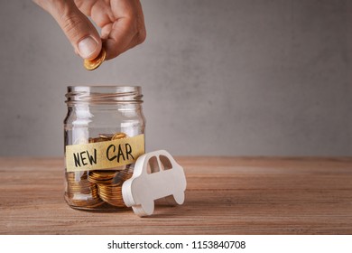 New car. Glass jar with coins and an inscription of new car and symbol of  car. Man holds coin in his hand - Shutterstock ID 1153840708